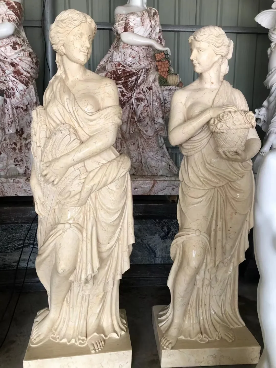 Close-up of classical marble caryatid statues showing natural stone veining, surface texture, and hand-carved sculptural detail