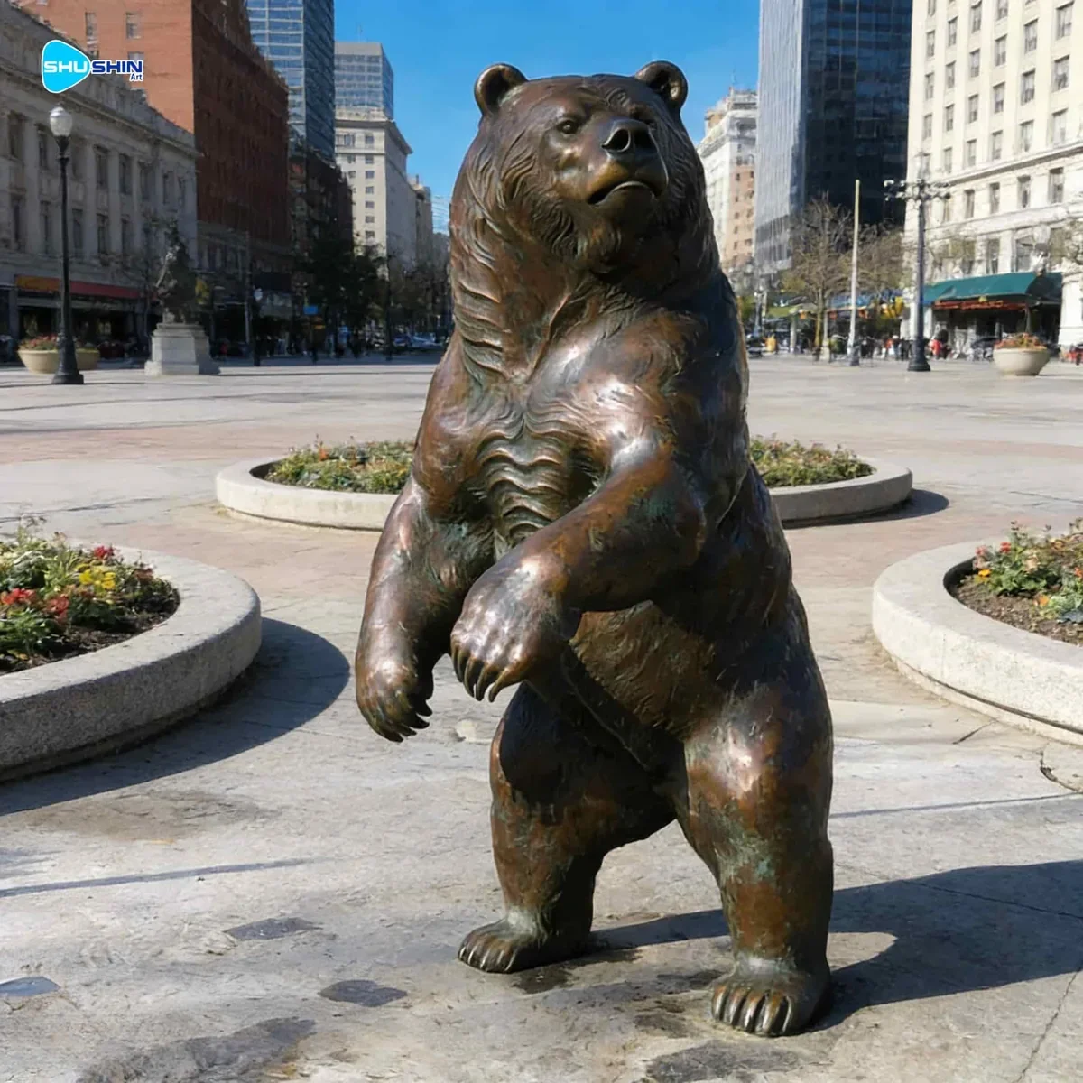 Lifelike bronze bear sculpture in an outdoor public space.