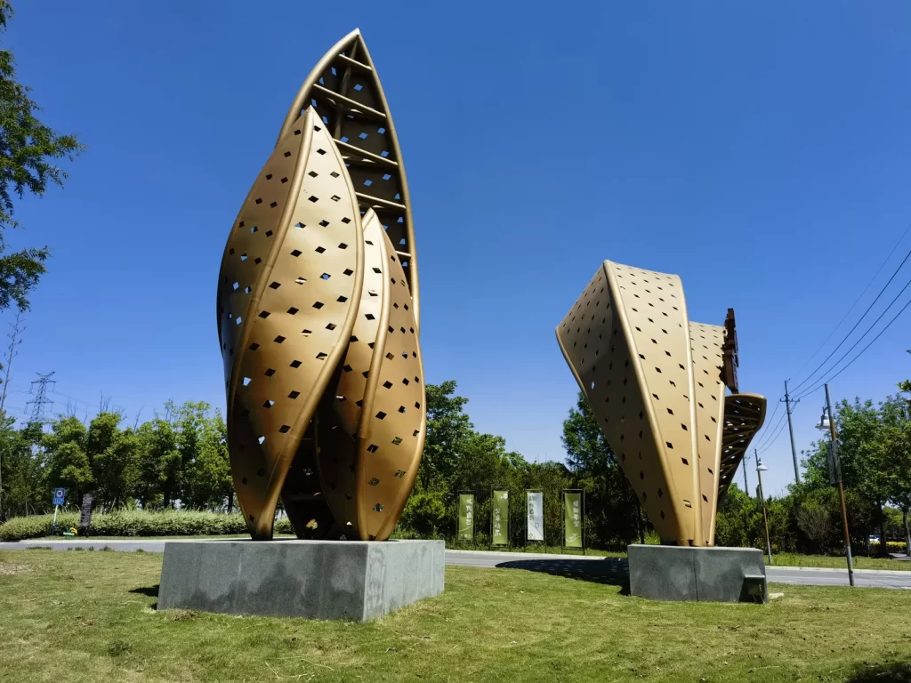 Large sculpture components displayed at an outdoor project site before on-site assembly.
