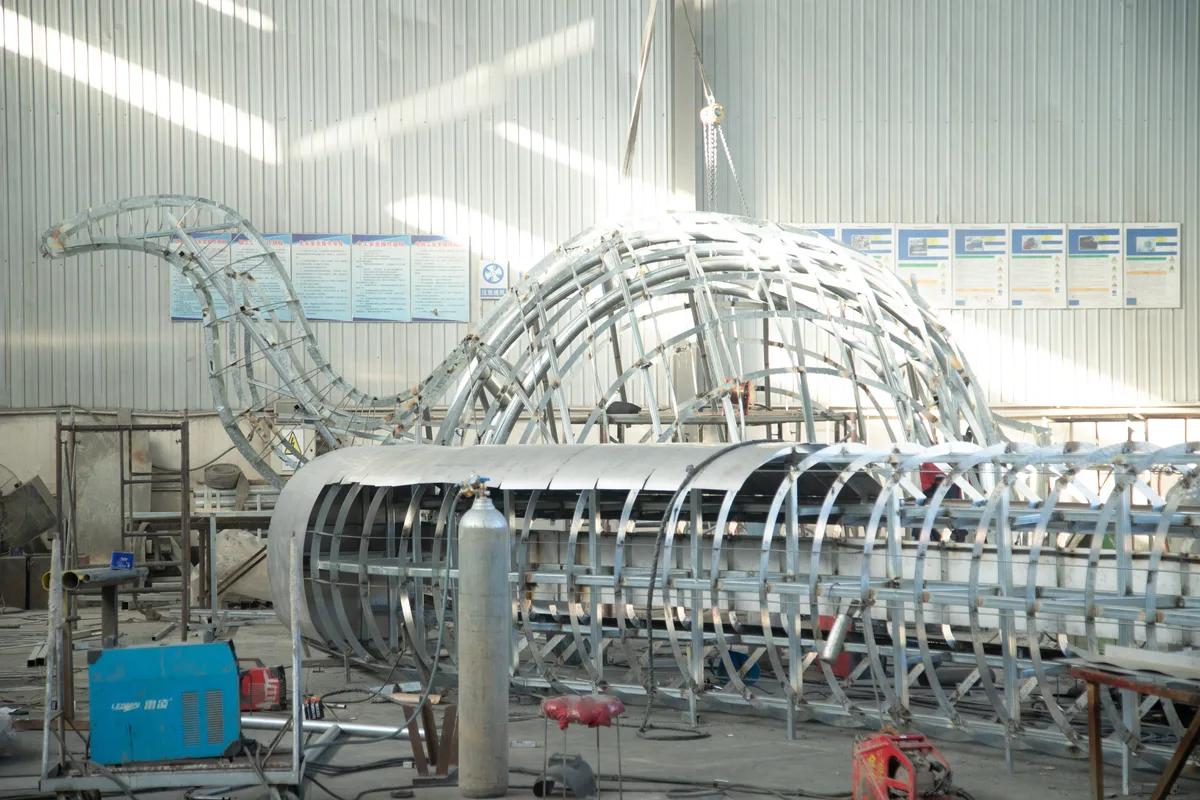 Segmented stainless steel sculpture framework showing modular design for transport.